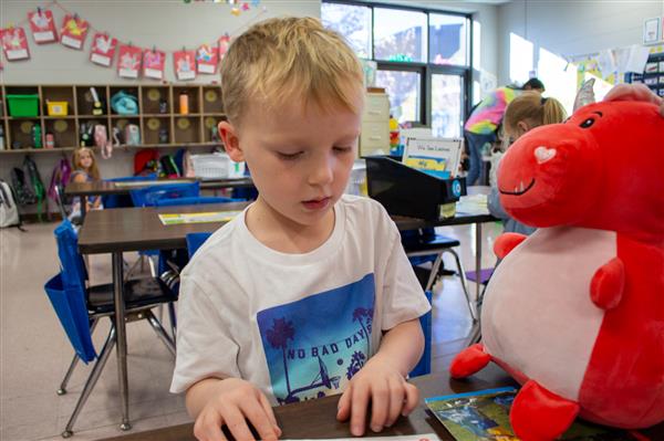 boy reading to stuffed animal
